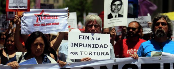 Manifestantes mantienen carteles con fotos de víctimas de la dictadura de Augusto Pinochet (archivo) Manifestantes mantienen carteles con fotos de víctimas de la dictadura de Augusto Pinochet (archivo) - Sputnik Mundo