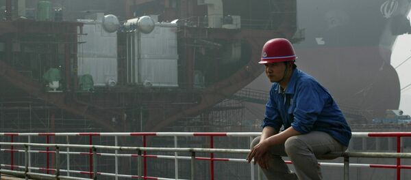A Chinese shipyard worker takes a break near a partially constructed 300,000 dwt class crude oil vessel at the Dalian New Shipbuilding Heavy Industry Co. Ltd, in Dalian, Northeast China, Friday, May 28, 2004. - Sputnik Mundo