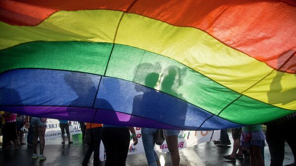 Members of the LGBT movement hold a gay pride flag as they attend a march to mark the International Day Against Homophobia in Managua, Nicaragua, Sunday, May 17, 2015. - Sputnik Mundo