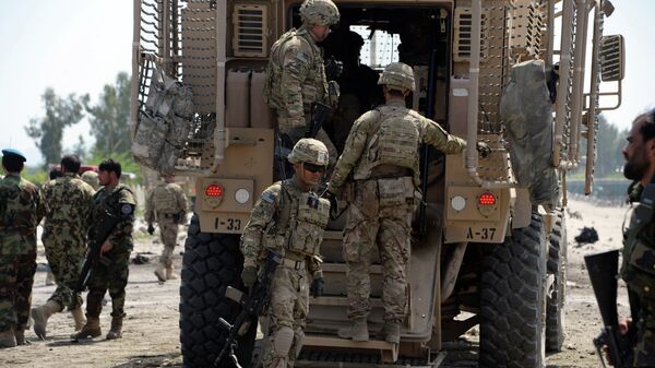 Afghan security personnel and US soldiers inspect the scene of a suicide attack near airport in Jalalabad on April 10, 2015. - Sputnik Mundo