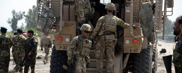 Afghan security personnel and US soldiers inspect the scene of a suicide attack near airport in Jalalabad on April 10, 2015. - Sputnik Mundo