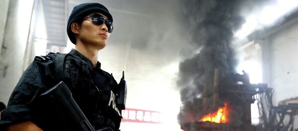 Agente de policía esta de guardia durante la destrucción de drogas en una empresa en Guiyang, China - Sputnik Mundo
