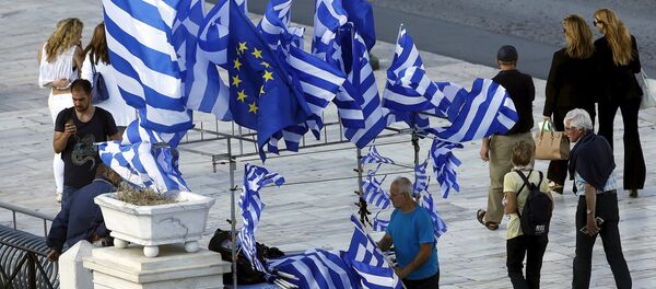 A street vendor sells Greek and EU flags before an upcoming demonstration by Greeks calling on the government to clinch a deal with its international creditors and secure Greece's future in the Eurozone in Athens, Greece, June 22, 2015 - Sputnik Mundo