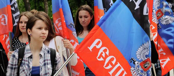 Representantes de la República Popular de Donetsk con las banderas de su república - Sputnik Mundo