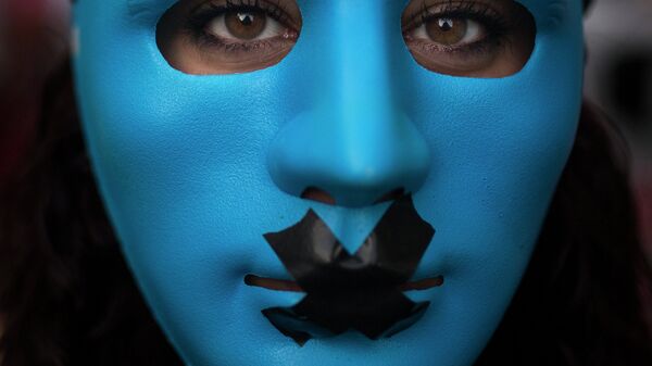 A protestor wears a mask with a gag as she marches against the Public Security Law in Madrid, Spain, Tuesday, June 30, 2015. - Sputnik Mundo