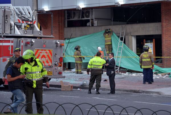 Colombian police officers and firefighters check the site of an explosion in the financial heart of Bogota - Sputnik Mundo