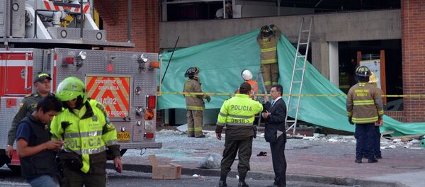 Colombian police officers and firefighters check the site of an explosion in the financial heart of Bogota - Sputnik Mundo