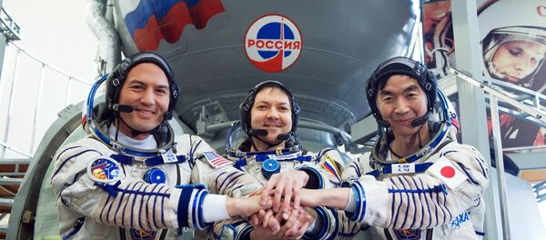 Tripulación de EEI-44/45 al lado de cohete Soyuz - Sputnik Mundo