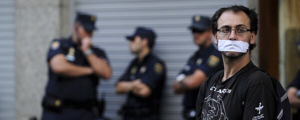 A man, with his mouth taped, during a protest against the Spanish government's new security law A man, with his mouth taped, during a protest against the Spanish government's new security law - Sputnik Mundo