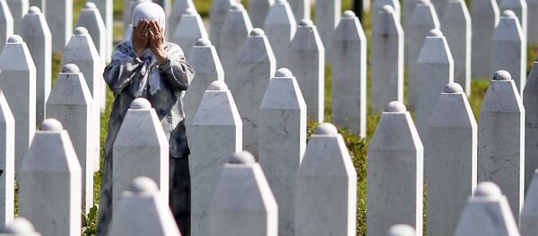 A woman prays near the grave of her relative, among 136 newly identified victims of the 1995 Srebrenica massacre - Sputnik Mundo