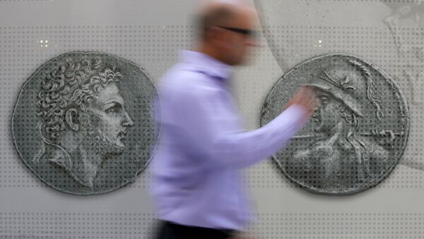 Un hombre camina delante de las monedas en el centro de Atenas. 13 de julio de 2015 - Sputnik Mundo