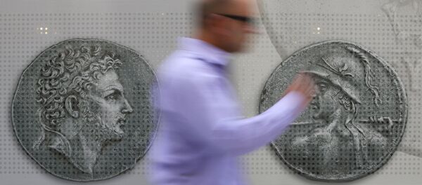 Un hombre camina delante de las monedas en el centro de Atenas. 13 de julio de 2015 - Sputnik Mundo