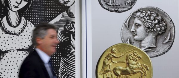 Un hombre camina delante de las monedas en el centro de Atenas, el 13 de julio, 2015 Un hombre camina delante de las monedas en el centro de Atenas, el 13 de julio, 2015 - Sputnik Mundo