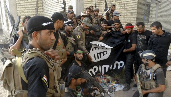 Fuerzas de seguridad de Irak con una bandera de Estado Islámico en provincia de Anbar, Irak, el 26 de julio, 2015 - Sputnik Mundo