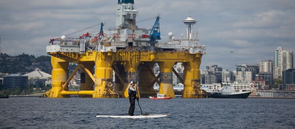 A man on a stand up paddle board is seen in front of the Shell Oil Company's drilling rig Polar Pioneer along the Puget Sound in Seattle, Washington - Sputnik Mundo