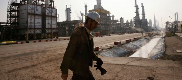 An Iranian oil worker makes his way through Tehran's oil refinery south of the capital Tehran, Iran - Sputnik Mundo