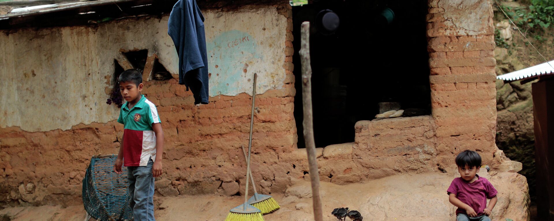 Niños permanecen frente a su humilde hogar en El Magueyito, estado de Guerrero, México, el 19 de julio de 2015 - Sputnik Mundo, 1920, 10.06.2023