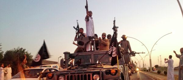 Fighters from the Islamic State group parade in a commandeered Iraqi security forces armored vehicle down a main road at the northern city of Mosul, Iraq - Sputnik Mundo