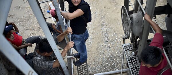 Central American migrants ride the train called The Beast in their attemp to reach the border between Mexico and The United States. - Sputnik Mundo