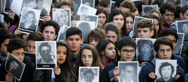 People hold pictures of the victims of the 1994 bombing of the AMIA Jewish community center on the 21st anniversary of the terror attack in Buenos Aires, Argentina - Sputnik Mundo