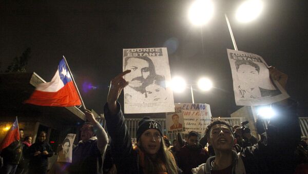 Demonstrators shout slogans as they gather outside the military hospital where Manuel Contreras, former head of ex-dictator Augusto Pinochet's feared secret police DINA, died in Santiago, Chile August 8, 2015. - Sputnik Mundo