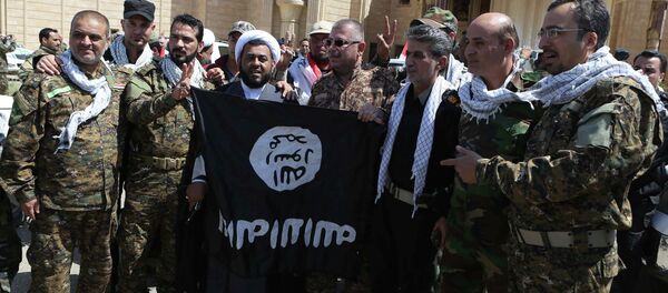 Fuerzas de Movilización Popular de Irak con la bandera del EI en Tikrit - Sputnik Mundo