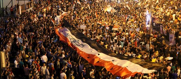 Iraquíes llevan la bandera nacional durante manifestación - Sputnik Mundo