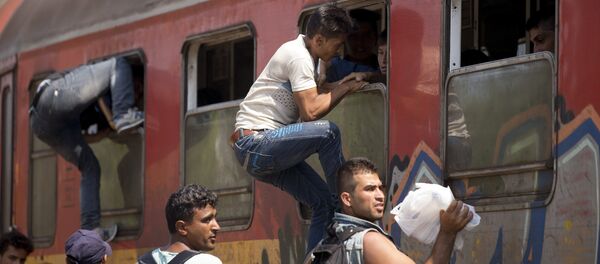 Migrantes abordan un tren en Macedonia - Sputnik Mundo