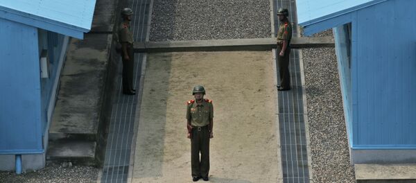 North Korean soldiers stand guard prior to a reunification rally in the border village of Panmunjom at the DMZ in North Korea, Saturday, Aug. 15, 2015. - Sputnik Mundo