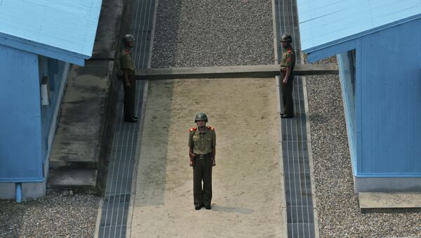 North Korean soldiers stand guard prior to a reunification rally in the border village of Panmunjom at the DMZ in North Korea, Saturday, Aug. 15, 2015. - Sputnik Mundo