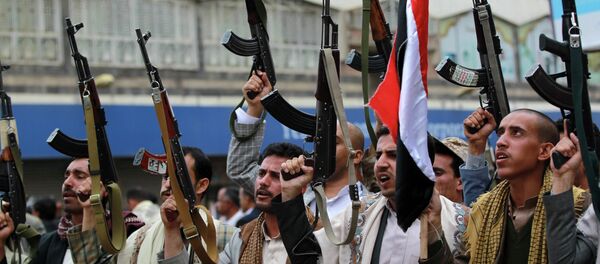 Shiite rebels, known as Houthis, hold up their weapons to protest against Saudi-led airstrikes, during a rally in Sanaa, Yemen, Thursday, March 26, 2015 - Sputnik Mundo