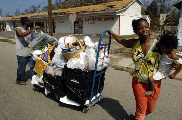 Afroamerican family push belongings they could salvage from their home in the Point Cadet neighborhood after being hit by Hurricane Katrina in Biloxi, Mississippi Afroamerican family push belongings they could salvage from their home in the Point Cadet neighborhood after being hit by Hurricane Katrina in Biloxi, Mississippi - Sputnik Mundo
