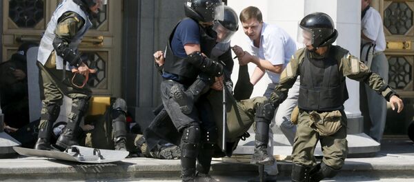 Militares ucranianos llevan un herido durante enfrentamientos junto a la sede del Parlamento ucraniano Militares ucranianos llevan un herido durante enfrentamientos junto a la sede del Parlamento ucraniano - Sputnik Mundo