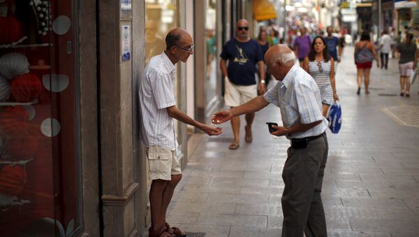 Un hombre da limosna a un mendigo en la ciudad de Ronda, España Un hombre da limosna a un mendigo en la ciudad de Ronda, España - Sputnik Mundo