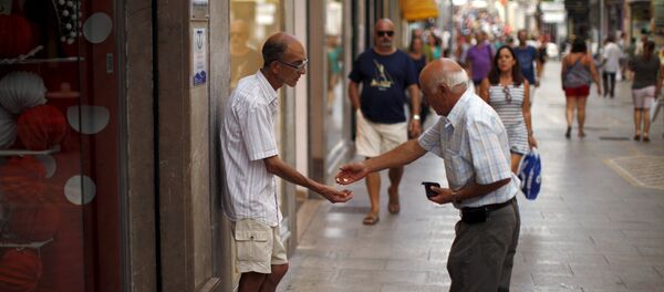 Un hombre da limosna a un mendigo en la ciudad de Ronda, España Un hombre da limosna a un mendigo en la ciudad de Ronda, España - Sputnik Mundo