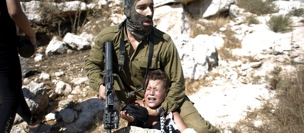 Un soldado israelí detiene a un niño palestino durante una protesta en la aldea cisjordana de Nabi Saleh - Sputnik Mundo