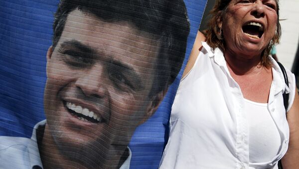 Participante de las manifestaciones con un retrato de Leopoldo López - Sputnik Mundo