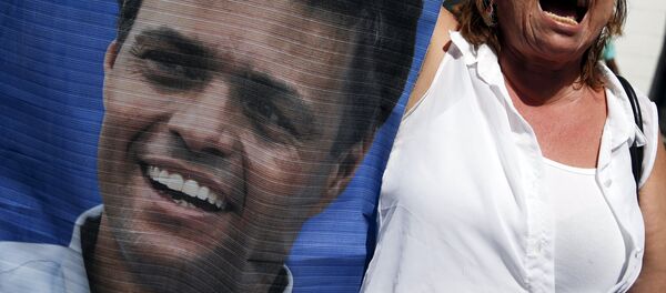 Participante de las manifestaciones con un retrato de Leopoldo López - Sputnik Mundo
