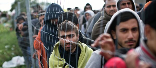 Refugiados esperan en una cola para subir a un autobús en Hegyeshalom, Hungría - Sputnik Mundo