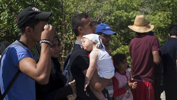 Refugiado con un niño en Grecia Refugiado con un niño en Grecia - Sputnik Mundo