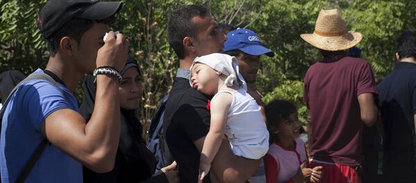 Refugiado con un niño en Grecia - Sputnik Mundo
