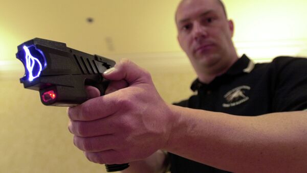 Clay Winn, of TASER International, demonstrates the company's Advanced M-26 model during a news conference in Las Vegas - Sputnik Mundo