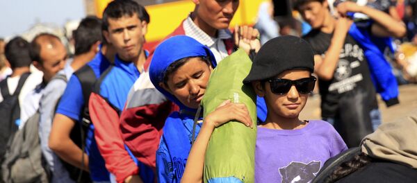 Los inmigrantes suben a un autobús después de cruzar la frontera de Serbia cerca Röszke, Hungría Los inmigrantes suben a un autobús después de cruzar la frontera de Serbia cerca Röszke, Hungría - Sputnik Mundo