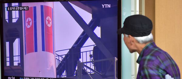 Un anciano ve las noticias sobre las reparaciones para el lanzamiento de un cohete norcoreano - Sputnik Mundo