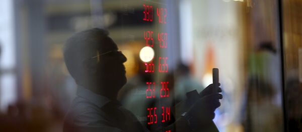 Reflejo de un hombre en el vidrio mientras toma imágenes de un tablero que muestra tipos de cambio de dólares y otras divisas - Sputnik Mundo