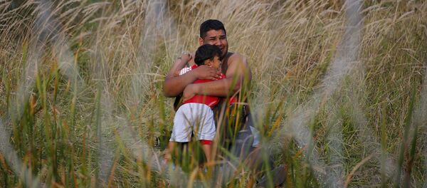 Migrante con su niño en Asotthalom, Hungría - Sputnik Mundo