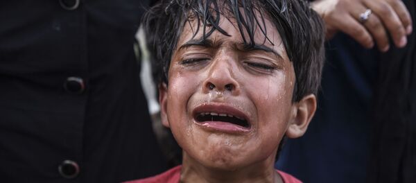 Un niño afectado por el gas lacrimógeno durante choques entre inmigrantes y policías en la frontera serbio-húngara Un niño afectado por el gas lacrimógeno durante choques entre inmigrantes y policías en la frontera serbio-húngara - Sputnik Mundo