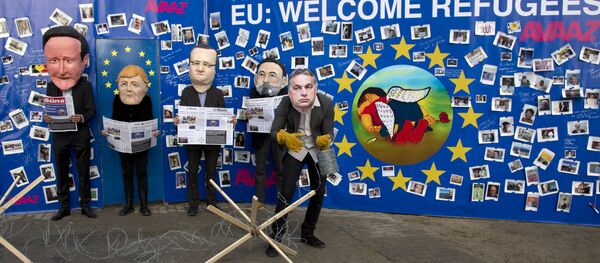 Actores disfrazados de David Cameron, Angela Merkel, Francois Hollande, Mariano Rajoy y Viktor Orbán cerca del retrato de Aylan Kurdi - Sputnik Mundo
