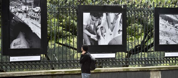 Un pasador mira a las fotos que demuestran las consecuencias del terremoto de 1985 en México - Sputnik Mundo