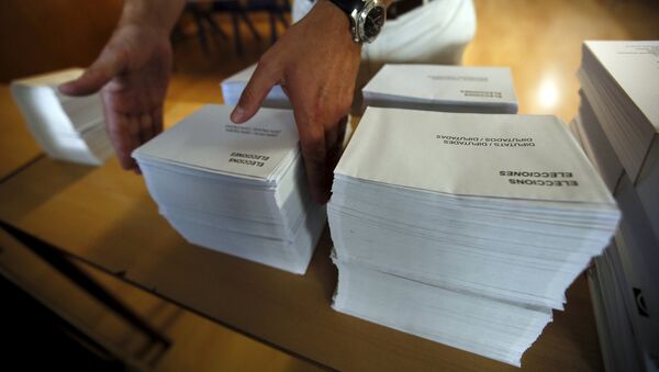 A man places ballots and envelopes on a table as the polling station is prepared inside a school in Barcelona, Spain, September 25, 2015.  - Sputnik Mundo